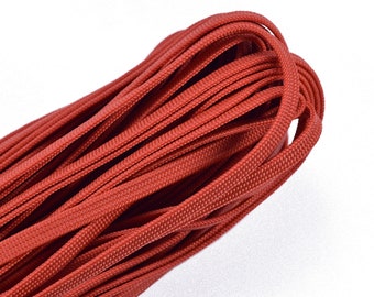 May include: A close-up of a red paracord, a type of strong nylon rope, coiled and ready for use.