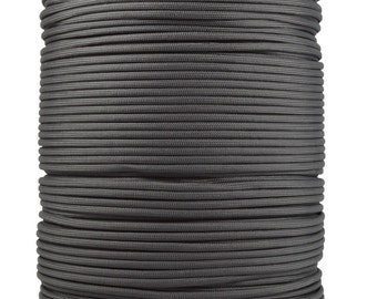 May include: A spool of gray paracord, a type of strong nylon rope, is wound tightly around a cardboard core.