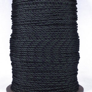 May include: A spool of black and green paracord with a camouflage pattern. The paracord is wound tightly around the spool.
