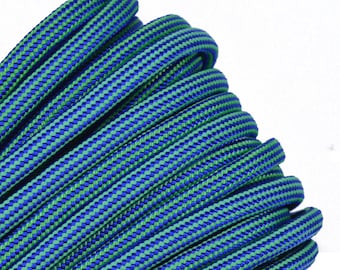 May include: A close-up of a blue and green paracord rope. The rope is coiled and has a checkered pattern.