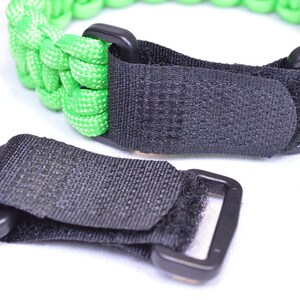 May include: A black adjustable strap with a hook and loop fastener. The strap is made of a woven material and has a black plastic buckle.