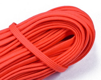 May include: A close-up of a spool of bright orange paracord. The cord is tightly wound and has a smooth, even texture.