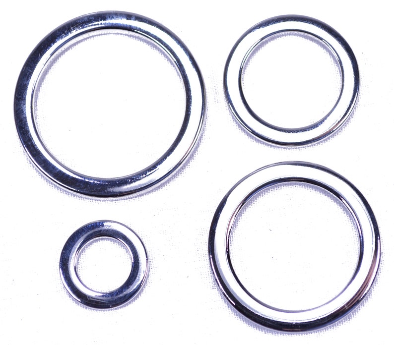 K&ouml;nnte beinhalten: Vier silberne Metallringe in verschiedenen Gr&ouml;&szlig;en. Die Ringe sind glatt und gl&auml;nzend.