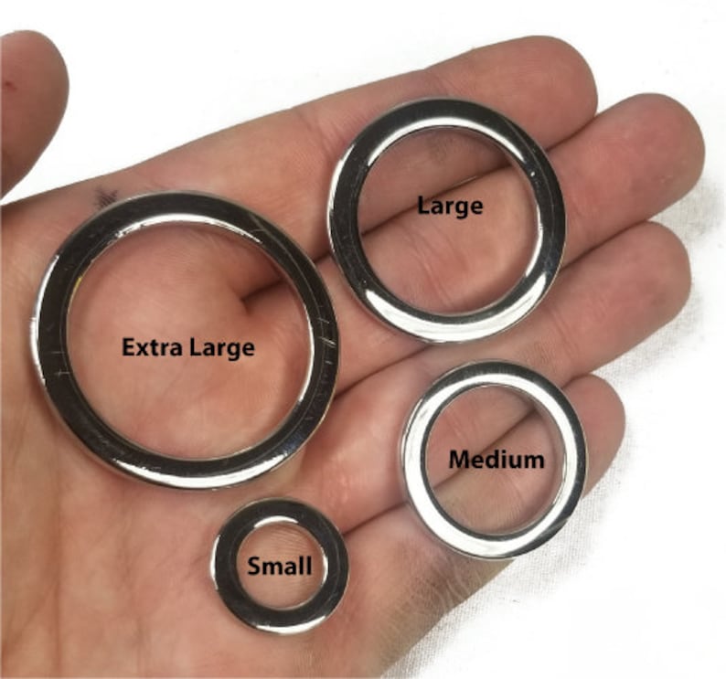 K&ouml;nnte beinhalten: Vier silberne Metallringe in verschiedenen Gr&ouml;&szlig;en. Die Ringe sind mit "Klein", "Mittel", "Gro&szlig;" und "Extra Gro&szlig;" beschriftet.