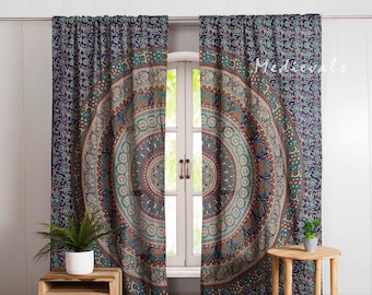 May include: A pair of blue and green mandala patterned curtains with a floral design. The curtains are hanging in a window with a wooden frame. The curtains are made of a soft, lightweight fabric and are perfect for adding a touch of bohemian style to any room.