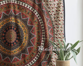 May include: A tapestry with a large, colorful mandala design featuring elephants and floral patterns. The tapestry is hanging on a wall and has a black border. A small wooden table with a potted plant sits in front of the tapestry.
