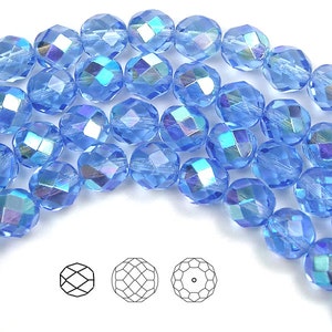 May include: A strand of light blue faceted glass beads with an iridescent finish. The beads are round and have a faceted design.