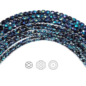 May include: A strand of iridescent blue faceted glass beads. The beads are arranged in a semi-circle, with the ends of the strand overlapping. The beads are all the same size and shape, and they have a shiny, reflective surface.