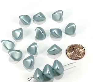 May include: A collection of light blue, pearlescent beads in a variety of shapes. Some beads are loose, while others are strung together on a wire. A US one-cent coin is included for size reference.