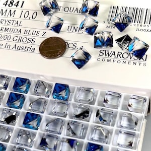 May include: A close-up of a box of 10mm square Swarovski crystals in the color Bermuda Blue. The crystals are in a clear plastic tray with a white background. The box is labeled with the Swarovski logo and the text "4841 MM 10,0 RYSTAL RMUDA BLUE Z 0/00 GROSS e in Austria UNF. PCS."