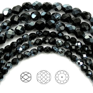 May include: A strand of black faceted glass beads with a metallic sheen. The beads are round and have a diamond-like shape. The beads are arranged in a circular pattern.