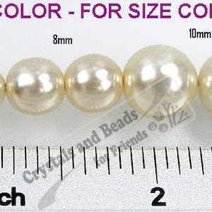 May include: A size comparison of white pearl beads, ranging in size from 2mm to 12mm. The beads are lined up on a white surface with a ruler underneath for reference. The text "NOT THE ACTUAL COLOR - FOR SIZE COMPARISON ONLY" is printed above the beads.