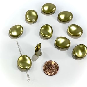 May include: A collection of olive-green, oval-shaped beads with a metallic sheen. One bead is strung on a wire, and another is shown as an earring. A penny is included for size reference. The beads are scattered on a white surface.