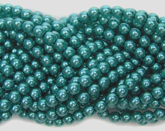 May include: A strand of teal green pearl beads. The beads are round and have a smooth, glossy finish.