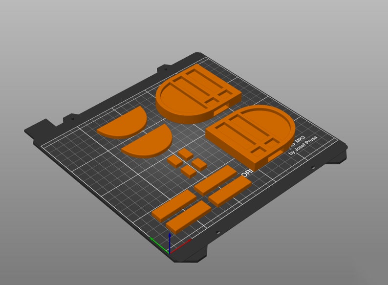 以下が含まれることがあります： オレンジ色のフィラメントで3DプリントされたPrusa i3 MK2プリンターのモデル。モデルは、フレーム、エクストルーダー、ベッドなど、いくつかの部品で構成されています。モデルは、グリッドパターンが施された黒いビルドプレートに印刷されています。