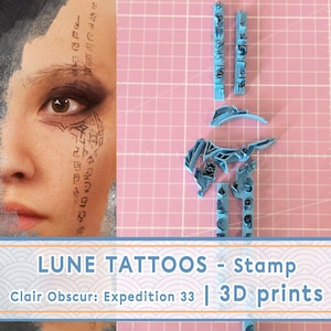 May include: Light blue 3D printed stamps and a partial image of a face with tattoo-like designs. The stamps are arranged on a pink grid surface. Text on the image reads "LUNE TATTOOS - stamp Clair Obscur: Expedition 33 | 3D prints."
