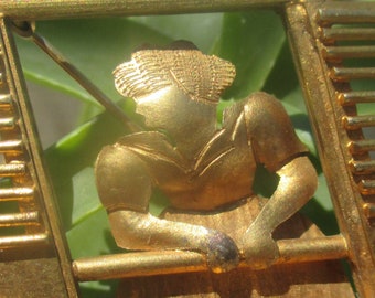 Remarkable art deco brooch, woman in window, stylized gold tone openwork
