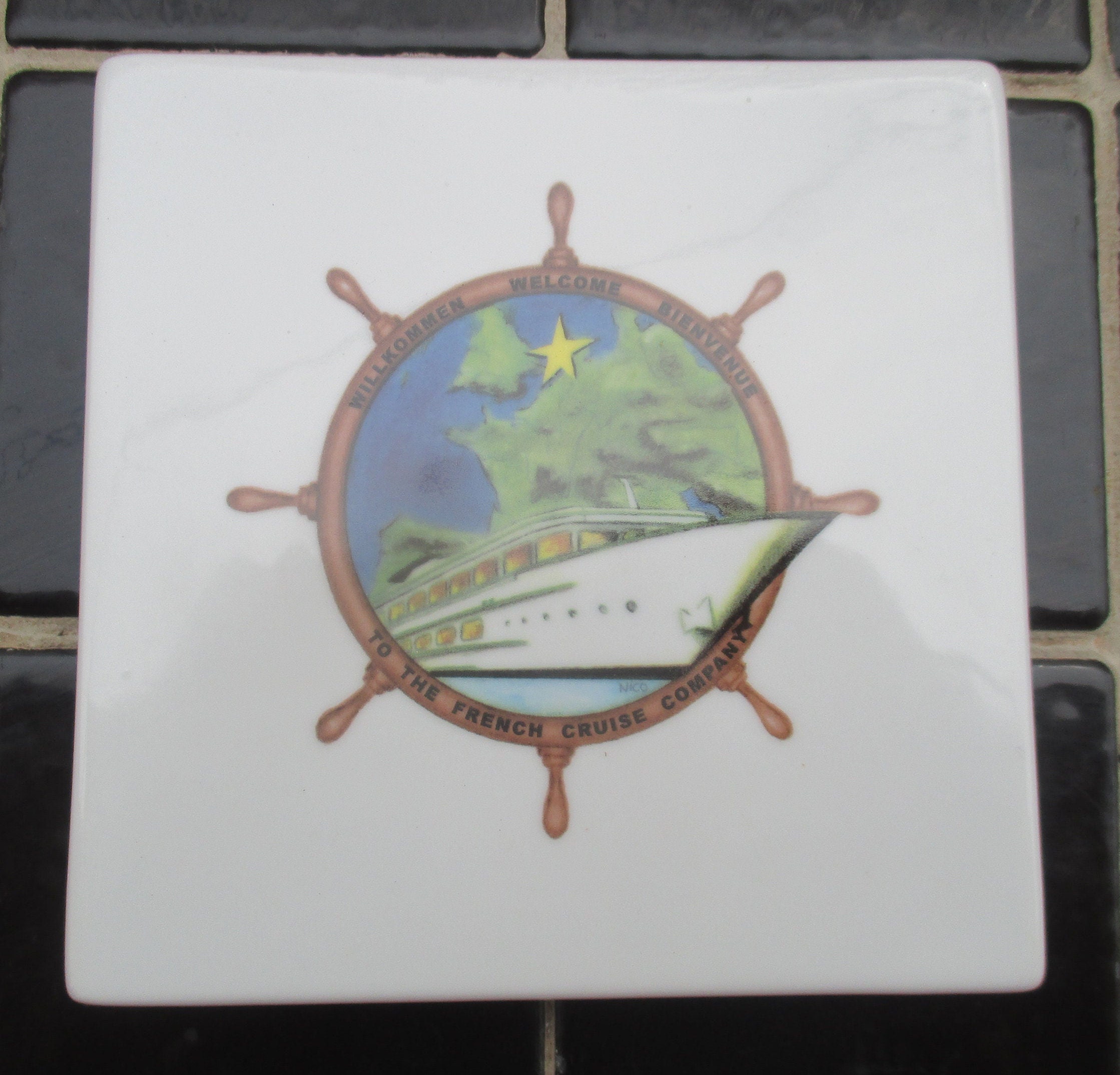 dessous de plat en porcelaine vintage sur le thème la marine, bateau aérodynamique, gouvernail, étoile et verdure signé anne ehret pour