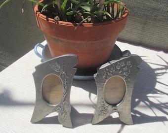 A pair of art nouveau frames, repoussé pewter on wood
