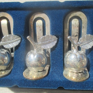 Coffret de 4 porte-noms pomme en métal argenté, légère ternissure, grandes et petites fentes et porte-serviettes