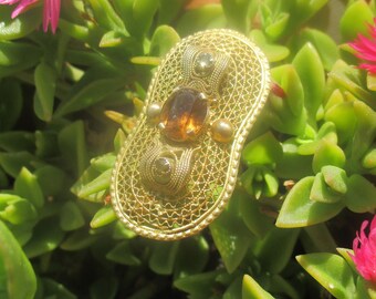 Gold tone metal hand worked wire brooch with topaz color glass stone, Etruscan style peanut shaped pin