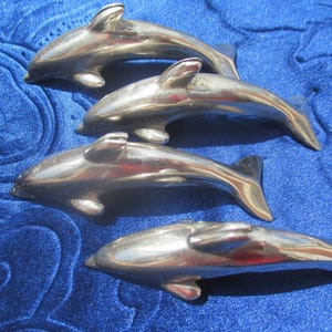 4 grands porte-cartes dauphins, métal argenté, patiné par l'oxydation