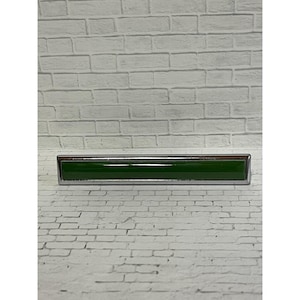 May include: A rectangular cabinet pull featuring a smooth, glossy forest green center inlay framed by a polished silver-tone metal border. The hardware has a sleek, elongated horizontal design with clean, straight edges and a reflective finish.
