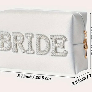 May include: White satin cosmetic bag with a zipper closure. The bag has the word "BRIDE" spelled out in pearl-like embellishments. The bag measures 8.1 inches by 5.1 inches by 2.8 inches.