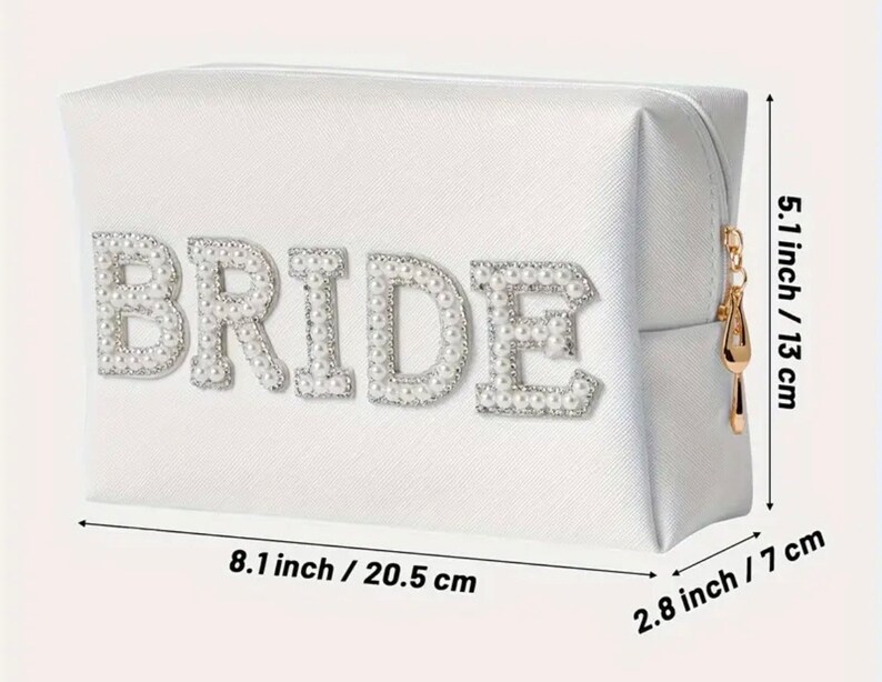 May include: White satin cosmetic bag with a zipper closure. The bag has the word "BRIDE" spelled out in pearl-like embellishments. The bag measures 8.1 inches by 5.1 inches by 2.8 inches.