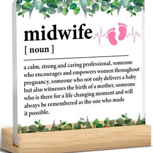 Peut inclure: Un bloc acrylique blanc avec une bordure de feuilles vertes et un graphique de battement de cœur rose. Le texte "midwife" est en gras noir avec la définition "une professionnelle calme, forte et attentionnée, qui encourage et responsabilise les femmes tout au long de la grossesse, qui non seulement accouche d'un bébé, mais assiste également à la naissance d'une mère, qui est là pour un moment qui change la vie et qui sera toujours considérée comme celle qui a rendu cela possible."