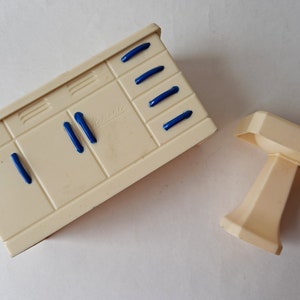 May include: A white plastic toy kitchen sink and cabinet set with blue handles. The cabinet has the word "Beswick" printed on the front.
