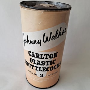 May include: A white cardboard tube with black text that reads "Johnny Walker Carlton Plastic Shuttlecocks Popular 3 Outdoor" and a black top and bottom.