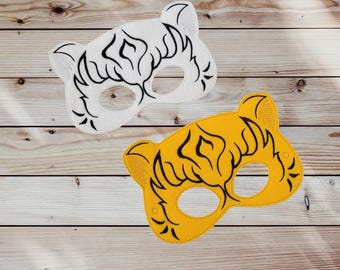 May include: Two felt tiger masks, one white with black stripes and one yellow with black stripes. The masks have eye holes and are designed for children's play.