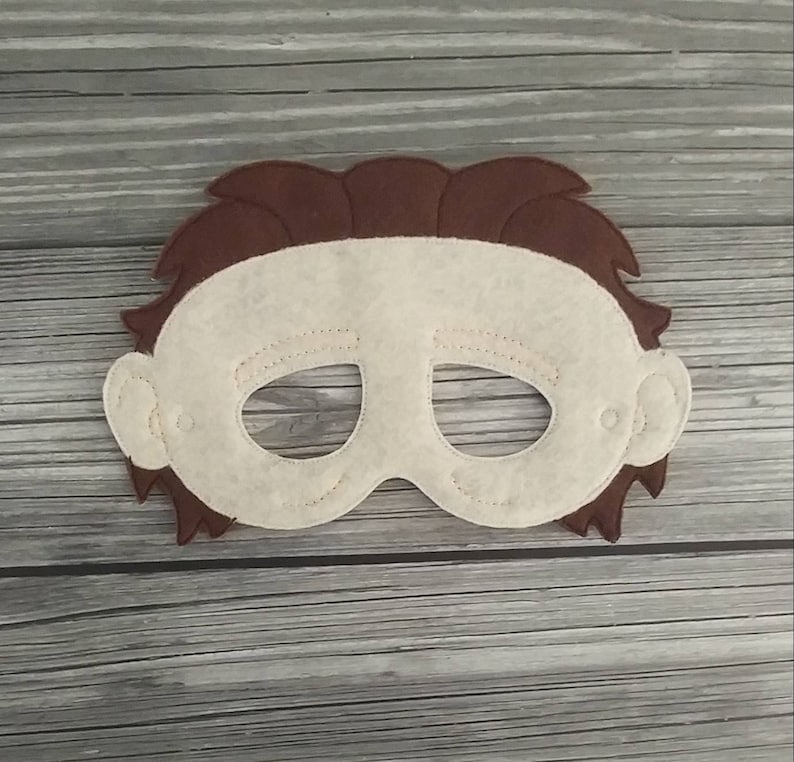 Op de afbeelding: Een viltmasker van een mensen gezicht met bruin haar en witte huid. Het masker heeft ooggaten en is bedoeld voor rollenspel.
