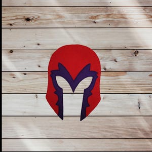 May include: Red felt mask with a purple helmet design. The mask is shaped like a head and has eye holes.