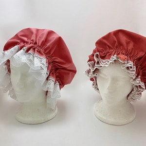May include: Two red and white fabric shower caps with lace trim. One cap has a small pink flower embellishment.