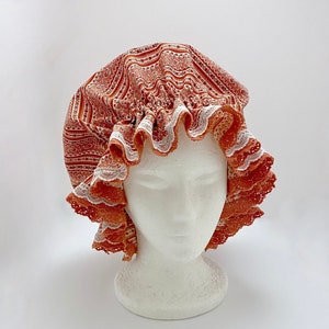 May include: A terracotta and white lace shower cap with a ruffled edge.