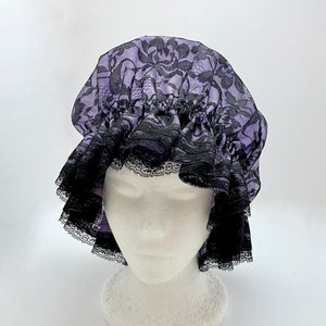 May include: A purple and black lace shower cap with a ruffled edge.