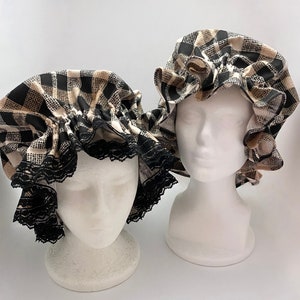 May include: Two black and white checkered fabric shower caps with ruffles. The caps are on white mannequin heads.