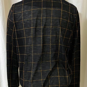 May include: Black long-sleeved shirt with a gold grid pattern.