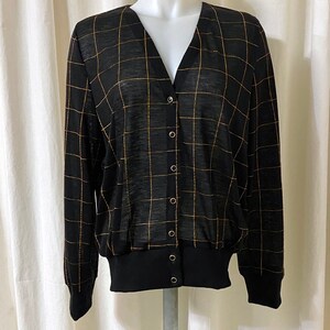 May include: Black and gold checkered cardigan with a v-neck and button closure.
