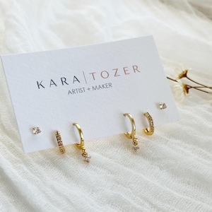 Puede incluir: Un juego de tres tazas de cerámica con un acabado mate moteado. Las tazas son de color crema, gris claro y gris oscuro. Cada taza tiene un diseño simple y minimalista.