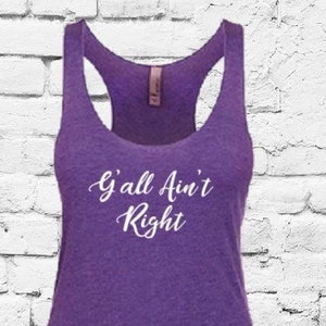 Puede incluir: Camiseta de tirantes morada con el texto "Y'all Ain't Right" en blanco.
