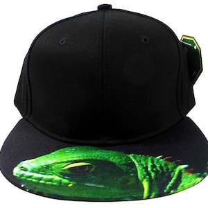 Könnte beinhalten: Schwarze und grüne Baseballkappe mit einem grünen Leguan-Motiv auf dem Schirm.