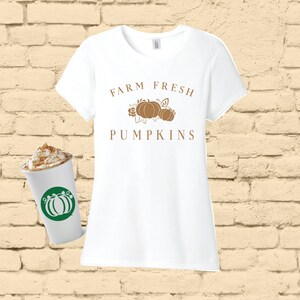 May include: White t-shirt with the text "FARM FRESH PUMPKINS" in brown lettering. A graphic of three pumpkins with leaves is above the text.