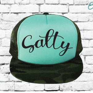 May include: A turquoise and camouflage trucker hat with the name "Sally" written in black cursive script.