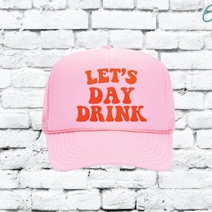 Può includere: Cappellino da camionista rosa con un font retrò rosso e arancione che dice "Let's Day Drink".