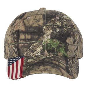 Puede incluir: Una gorra de b&eacute;isbol de camuflaje con un peque&ntilde;o parche de la bandera estadounidense en el lateral. La gorra est&aacute; hecha de un tejido suave y transpirable y presenta un dise&ntilde;o cl&aacute;sico de seis paneles.