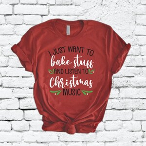 May include: Red t-shirt with white text that reads "I just want to bake stuff and listen to Christmas music".