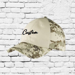 May include: A beige and camouflage baseball cap with the word "Custom" embroidered on the front.